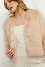 Load image into Gallery viewer, Woman wearing a blush faux fur jacket with pearl embellishments, a vanilla top and vanilla pants against a white wall.
