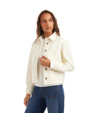 Load image into Gallery viewer, Woman wearing an off-white jacket over a white top and blue jeans against a white background.
