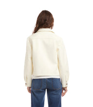 Load image into Gallery viewer, Woman wearing an off-white jacket over a white top and blue jeans against a white background.
