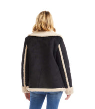 Load image into Gallery viewer, Woman wearing a black coat with cream shearling trim and blue jeans against a white background.
