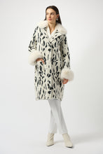 Load image into Gallery viewer, Woman wearing a white and black animal print coat with fur trim, white pants and white boots against a white background.

