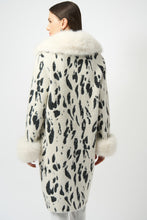 Load image into Gallery viewer, Woman wearing a white and black animal print coat with white fur trim against a white background.
