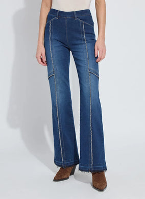 Model wearing fringe blue jeans and brown suede boots against a white background.