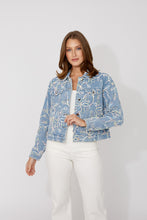 Load image into Gallery viewer, Woman wearing a blue and multi-color embroidered floral patterned jacket and white jeans against a white background.
