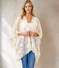 Load image into Gallery viewer, Woman wearing a floral gold and off-white kimono over a white top and blue jeans, standing against a neutral wall.
