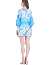 Load image into Gallery viewer, Woman wearing a blue floral outfit and clear heels on a white background.
