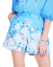 Load image into Gallery viewer, Person wearing blue floral shorts with a matching top on a white background.
