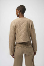 Load image into Gallery viewer, Woman wearing a warm taupe quilted jacket with silver embellishments and warm taupe jeans against a white background.
