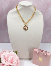 Load image into Gallery viewer, This vintage Chanel button is a rare find, featuring gold and red coloring detailing with slight Chanel wording in the center. The piece features a gleaming gold-plated rolo chain, paired with a base adorned with dazzling clear crystals, creating a stunning and attention-grabbing appearance.
