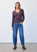 Load image into Gallery viewer, Woman wearing blue jeans with a patterned shirt and brown shoes against a plain background.
