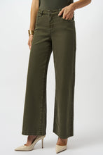 Load image into Gallery viewer, Woman wearing an avocado green top, avocado green wide leg denim and off white heels against a white background.
