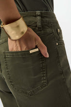 Load image into Gallery viewer, Closeup of the signature JR tag on back pocket of avocado green denim pant against a white background.
