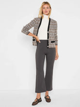 Load image into Gallery viewer, Woman wearing a black multicolored cardigan over a white turtleneck, grey pants and patterned flats against a white background.
