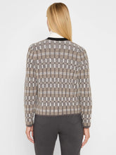 Load image into Gallery viewer, Woman wearing a black multicolored cardigan over a white turtleneck and grey pants against a white background. 
