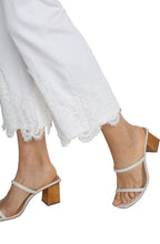 Load image into Gallery viewer, Close-up of white lace detail on bottom hem and white sandals against a white background.
