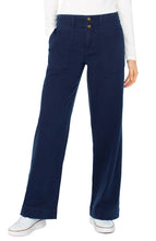 Load image into Gallery viewer, Model wearing navy blue jeans, white top and white sneakers against a white background.
