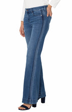 Load image into Gallery viewer, Model wearing blue jeans with side striping, white top and black heels against a white background.
