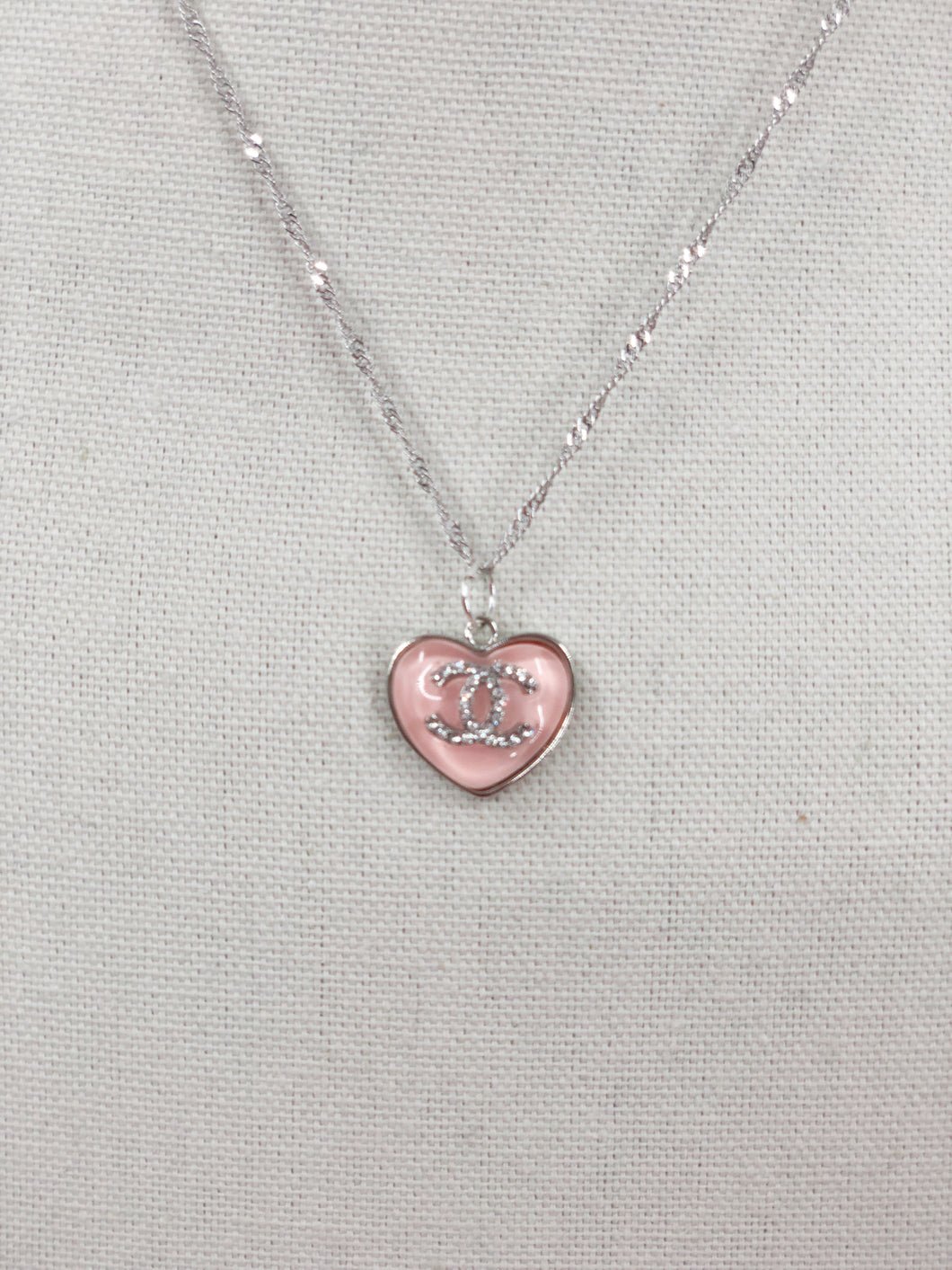 This unique piece is a valuable find. The delicate vintage CC heart zipper pull, adorned with dazzling clear crystals, adds a touch of charm in soft pink. Exude radiance and make a statement when you wear this gorgeous piece.