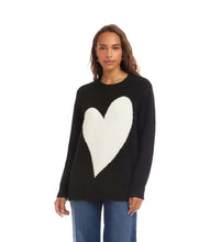 Load image into Gallery viewer, Woman wearing a black sweater with a large white heart design and blue jeans against a white backdrop.
