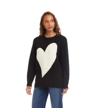 Load image into Gallery viewer, Woman wearing a black sweater with a large white heart design and blue jeans against a white background.
