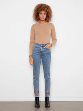 Load image into Gallery viewer, Woman wearing a brown knit top, blue jeans with embroidered hem and black boots against a grey background.
