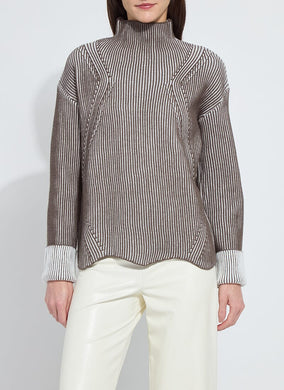 Model wearing a striped sweater and white pants against a plain background.