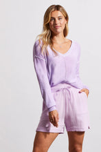 Load image into Gallery viewer, One of our top sellers, this light and adaptable V-neck sweater is a perfect choice for casual, trendy fashion.  Our gorgeous sweater offers a stunning light purple color, pop-over design and long sleeves with drop shoulders, an exposed center seam, and a high-low hem with side-slit details.  Color - Iris. Pop-over v-neck. Long sleeve with drop shoulder Exposed center seam; high-low hem with side slits Special reverse bleach print Fabric - 100% Cotton.
