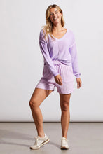 Load image into Gallery viewer, One of our top sellers, this light and adaptable V-neck sweater is a perfect choice for casual, trendy fashion.  Our gorgeous sweater offers a stunning light purple color, pop-over design and long sleeves with drop shoulders, an exposed center seam, and a high-low hem with side-slit details.  Color - Iris. Pop-over v-neck. Long sleeve with drop shoulder Exposed center seam; high-low hem with side slits Special reverse bleach print Fabric - 100% Cotton.
