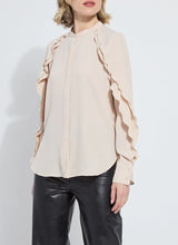 Load image into Gallery viewer, Model wearing a rose petal colored blouse with ruffle detailing and black pants against a white background.
