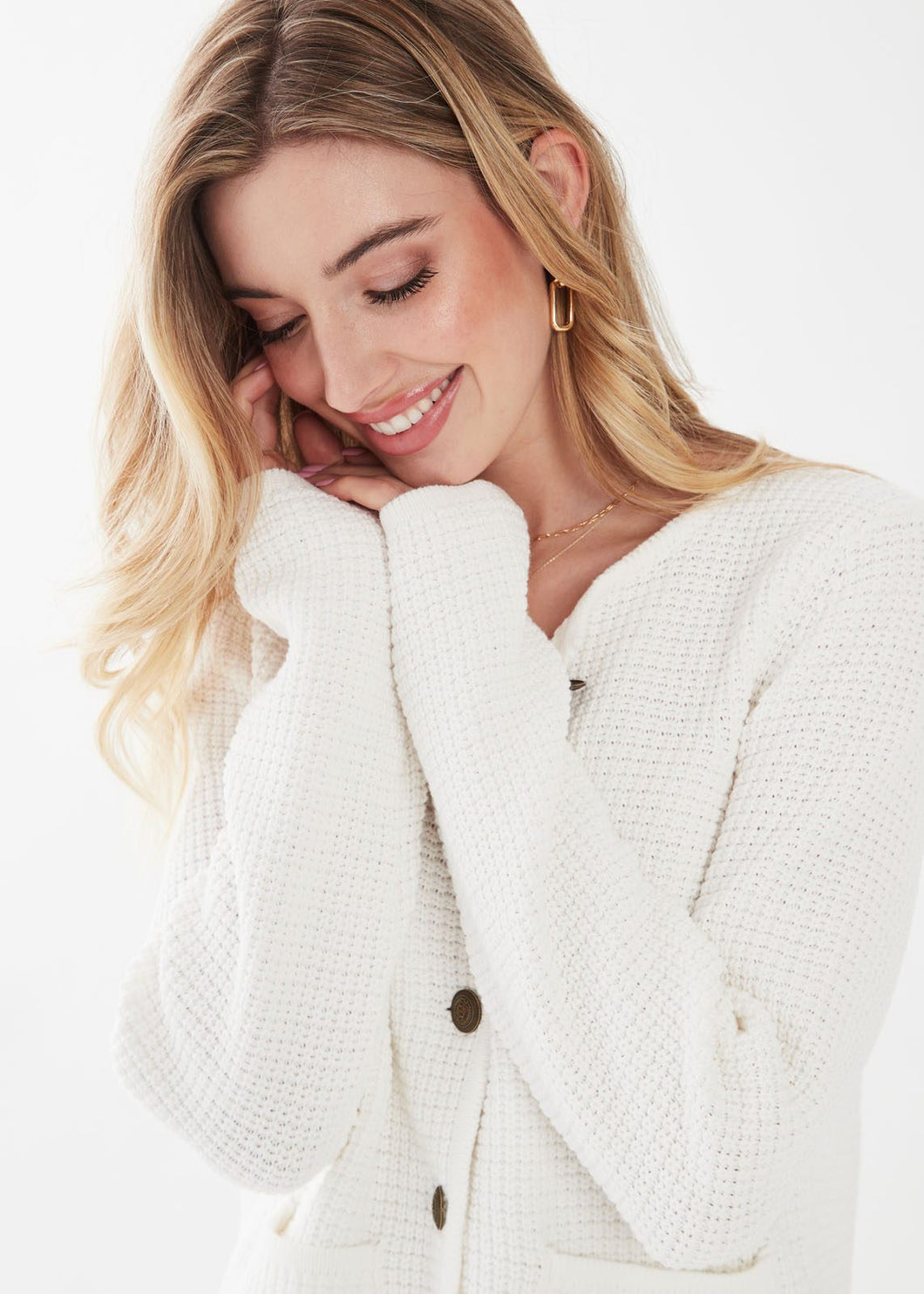 This beautiful ivory cardigan jacket features classic antique gold buttons, adding a sophisticated accent to your look while providing functionality. It can be worn alone or layered over a top, making it a versatile and stylish choice for any outfit.  Color- Ivory. Antique gold buttons. Button down. Layer over top or wear alone. Waffle knit. Front functional pockets.