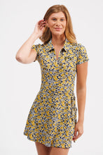 Load image into Gallery viewer, A woman modeling a short-sleeve collared mini dress with a yellow, black, and white abstract pattern, set against a plain light gray background.
