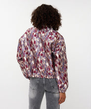 Load image into Gallery viewer, Model wearing a mosaic patterned jacket and grey jeans against a white background.
