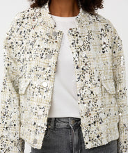Load image into Gallery viewer, Model wearing an off-white silver sequin bomber jacket over a white top and grey jeans against a white background.
