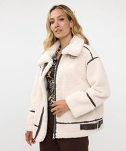 Load image into Gallery viewer, The luxurious Faux Fur Aviator Jacket in creamy ivory is a fashion statement. It boasts a plush faux fur exterior, complemented by dark brown leather accents and an elegant buckle detail for extra style. The inside is made of velvety suede that adds extra warmth. Designed with long sleeves and a zip-up closure, it&#39;s not only chic but also practical, ensuring warmth and fashion throughout the cooler seasons.
