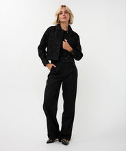 Load image into Gallery viewer, Woman wearing a black sequin jacket, black pants, silver hoop earrings and sequin heels against a white background.
