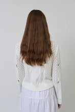 Load image into Gallery viewer, Woman wearing a white and multicolored cardigan and white skirt against a plain background.

