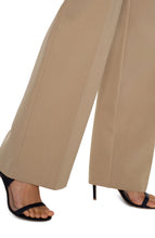Load image into Gallery viewer, Close up of beige trouser and black heels against a white background.

