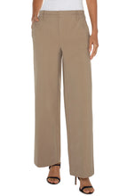 Load image into Gallery viewer, Model wearing beige trousers, white top and black heels against a white background.
