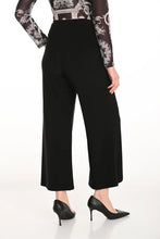 Load image into Gallery viewer, Close up of a woman wearing black wide leg pants with scalloped hem, black heels and printed top against a white background.

