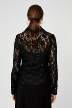 Load image into Gallery viewer, Woman wearing a black lace blouse and black skirt against a white background.
