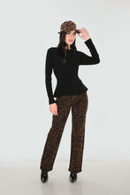 Load image into Gallery viewer, A woman modeling a black long-sleeve peplum top paired with brown leopard-print pants, a matching leopard-print hat, and black pointed shoes against a light gray studio background.
