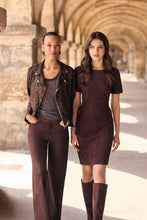 Load image into Gallery viewer, Two women modeling coordinated brown outfits in a sunlit stone arcade. The woman on the left wears a leopard-print moto jacket with brown pants, and the woman on the right wears a dark brown short-sleeve dress with matching knee-high boots.
