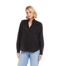 Load image into Gallery viewer, Woman wearing a black blouse with embellishments and light blue jeans on a white background.
