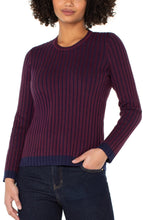 Load image into Gallery viewer, Woman wearing a ribbed long-sleeve top in burgundy and navy and blue jeans against a white background.
