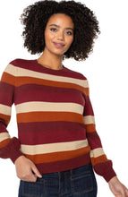 Load image into Gallery viewer, Model wearing burgundy multicolor striped crewneck sweater and blue jeans against a white background.
