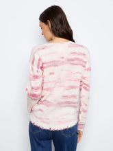 Load image into Gallery viewer, A woman viewed from the back wearing a long-sleeve knit sweater with a pink and off-white pattern, paired with blue jeans, against a plain white background.

