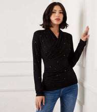 Load image into Gallery viewer, Woman wearing a black long-sleeve crossover top with sparkles and jeans against a white wall.
