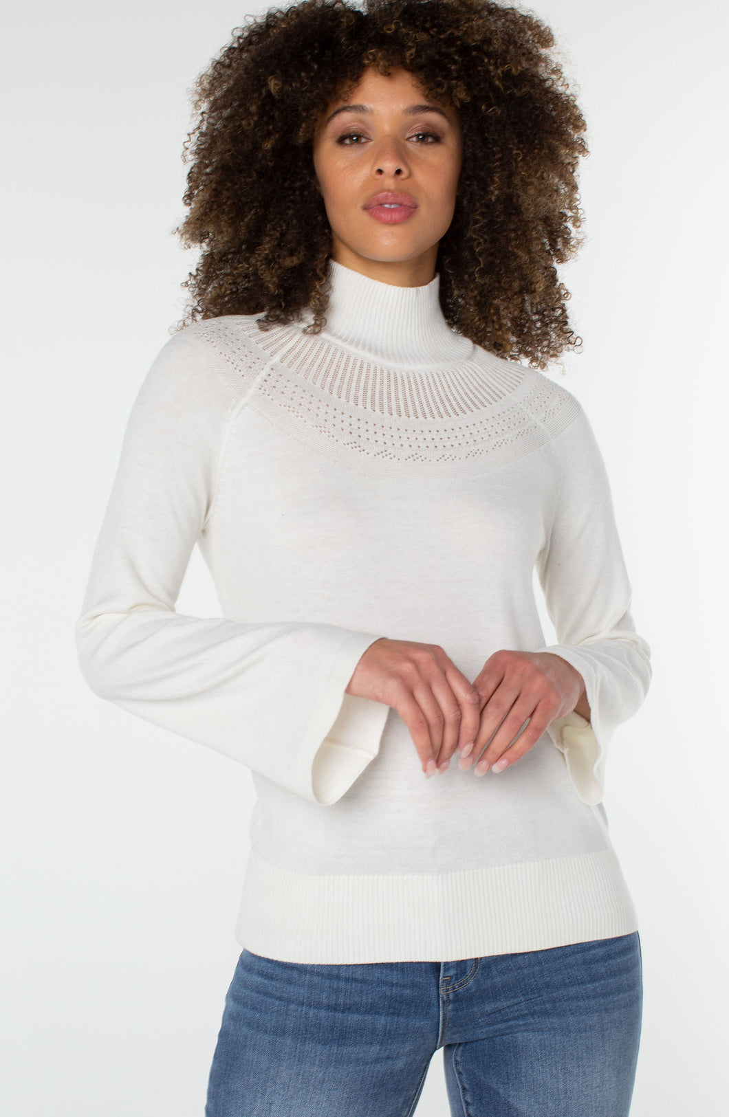This timeless sweater is a classic blend of style and comfort. Crafted from a luxurious fabric in a porcelain white, with intricate pointelle stitching, it features a funnel neck and bell sleeves. Perfect for layering or wearing solo, it's a wardrobe essential. Color- Porcelain. Sweater yarn fabrication. Mock neckline. Bell sleeves. Pointelle detailing. Pullover construction.