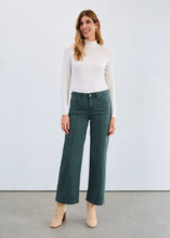 Load image into Gallery viewer, Woman wearing a cream mock neck, green jeans and cream boots against a plain background.
