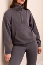 Load image into Gallery viewer, Woman wearing a gray casual zip up top, matching gray jogger standing against a white wall.
